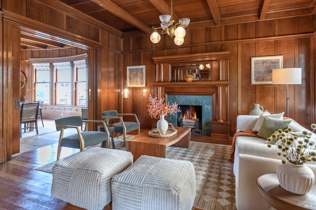 living area featuring wooden ceiling, wood walls, beamed ceiling, a chandelier, and a fireplace