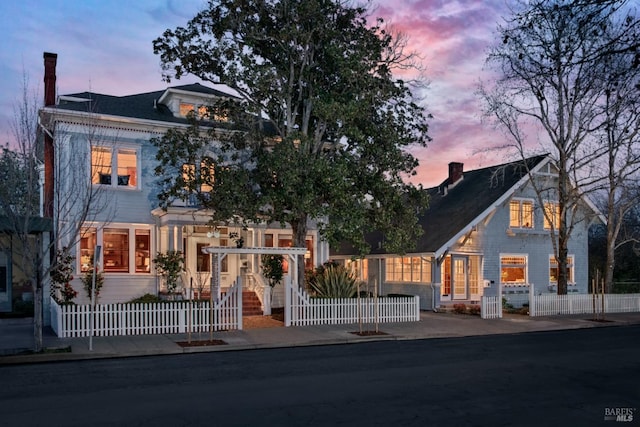 view of front of house with a fenced front yard and a chimney