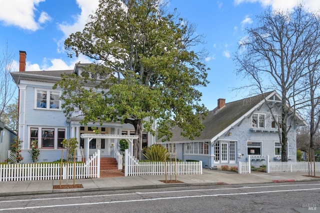 view of front of house with a chimney and a fenced front yard