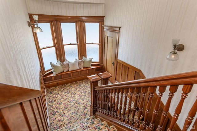 stairs featuring wallpapered walls and carpet