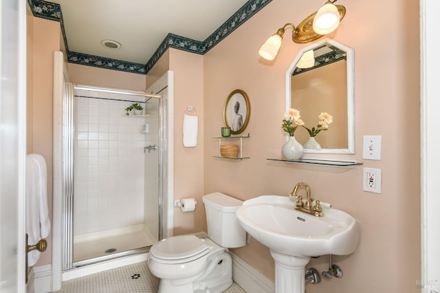 full bath featuring a stall shower, toilet, baseboards, and tile patterned floors