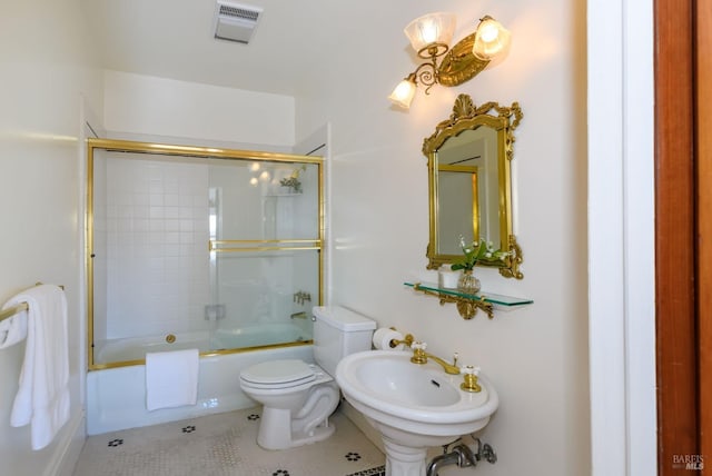 full bathroom featuring toilet, tile patterned floors, a sink, and enclosed tub / shower combo