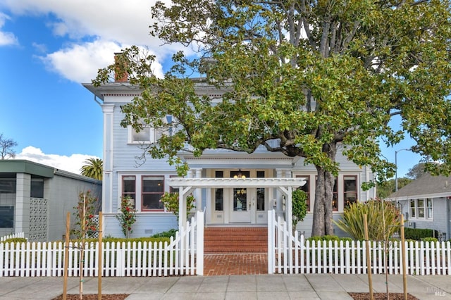 view of front of house with a fenced front yard and a chimney