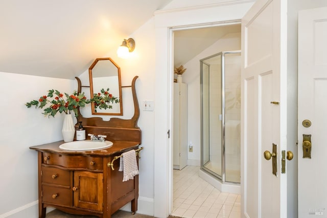 full bath with a stall shower, vanity, tile patterned floors, baseboards, and lofted ceiling