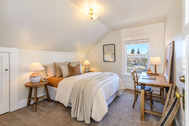 carpeted bedroom featuring lofted ceiling and baseboards
