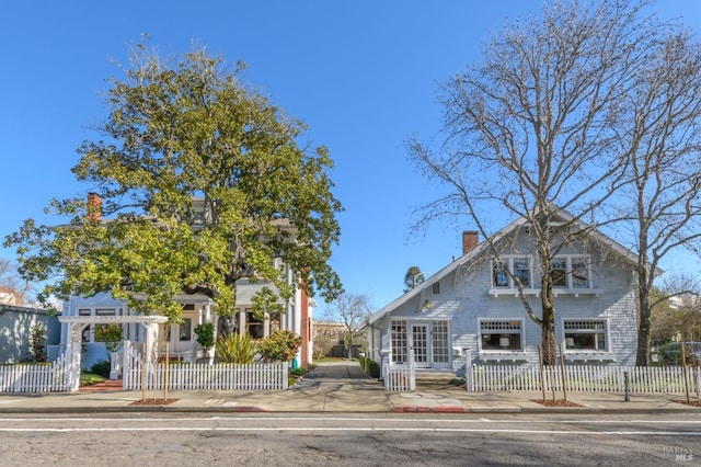 view of front facade featuring a chimney and a fenced front yard
