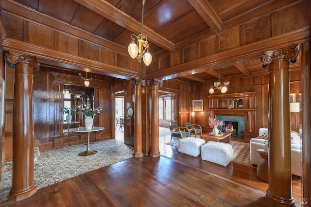 living room with wood ceiling, decorative columns, wood walls, wood finished floors, and a fireplace