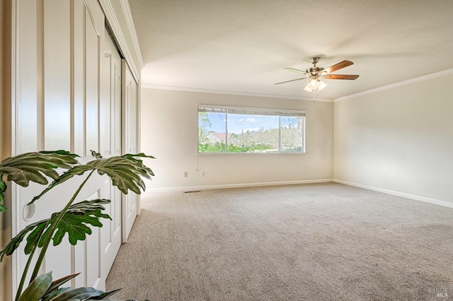 unfurnished room with light carpet, baseboards, ornamental molding, and a ceiling fan