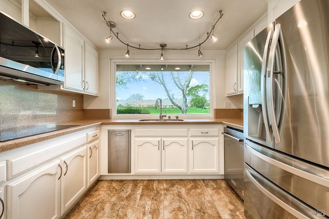 kitchen with white cabinetry, rail lighting, a sink, and stainless steel appliances