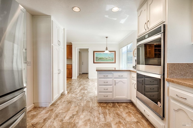 kitchen featuring decorative light fixtures, ornamental molding, white cabinets, a peninsula, and appliances with stainless steel finishes