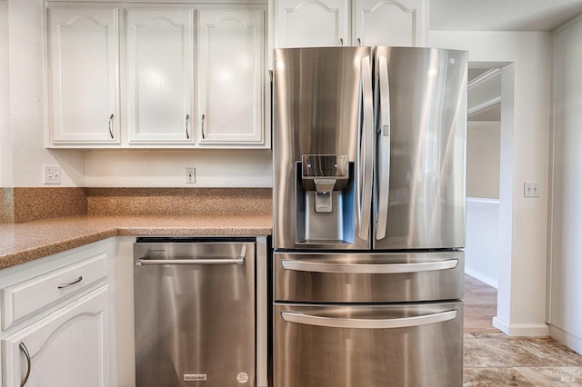 kitchen featuring white cabinetry, light stone countertops, and stainless steel appliances