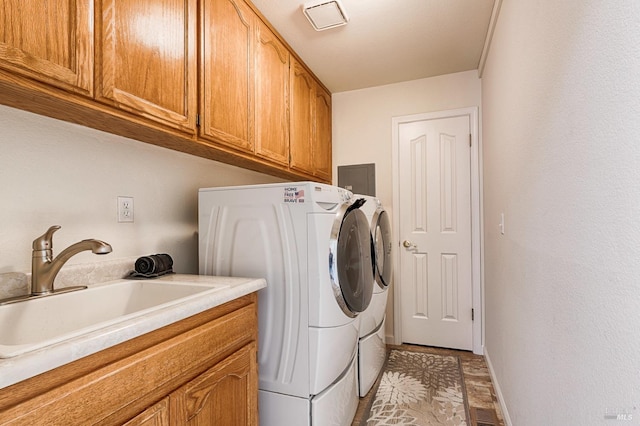 laundry area with a sink, washing machine and clothes dryer, baseboards, visible vents, and cabinet space