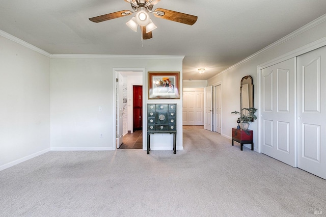 unfurnished room with a ceiling fan, ornamental molding, carpet, and baseboards