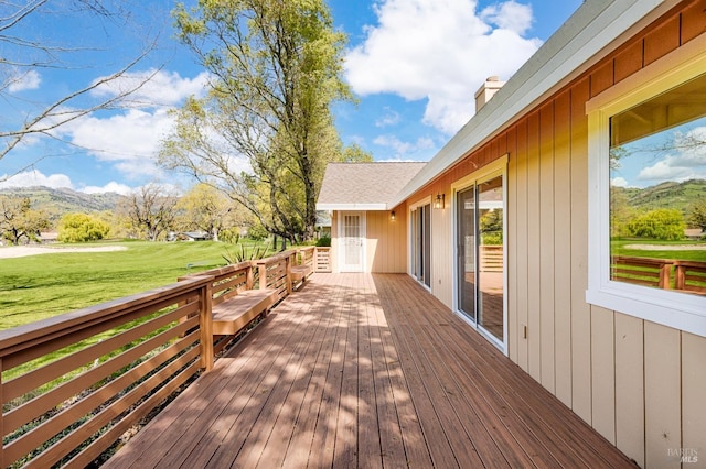 deck with a mountain view and a yard
