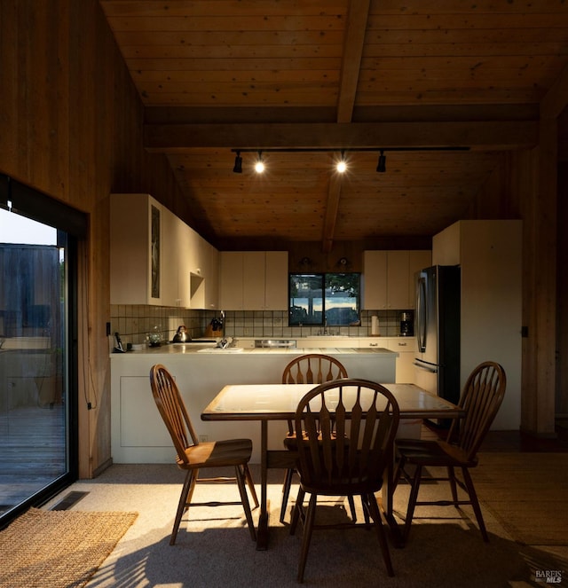 kitchen featuring white cabinetry, wood ceiling, stainless steel refrigerator, and decorative backsplash