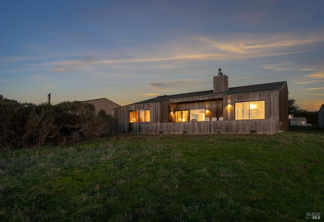 back house at dusk with a yard