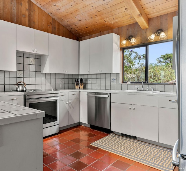 kitchen with stainless steel appliances, sink, white cabinets, and backsplash