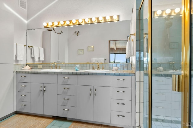 bathroom featuring vanity and a shower with shower door