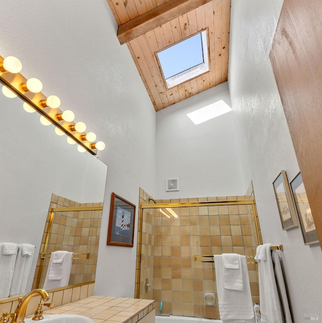 bathroom featuring high vaulted ceiling, a skylight, vanity, wood ceiling, and beam ceiling