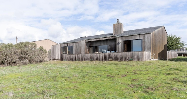 rear view of property with a lawn