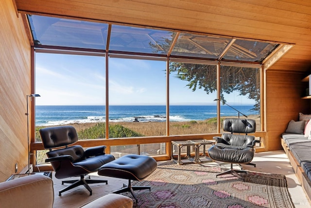 sunroom / solarium featuring a view of the beach, a healthy amount of sunlight, and a water view