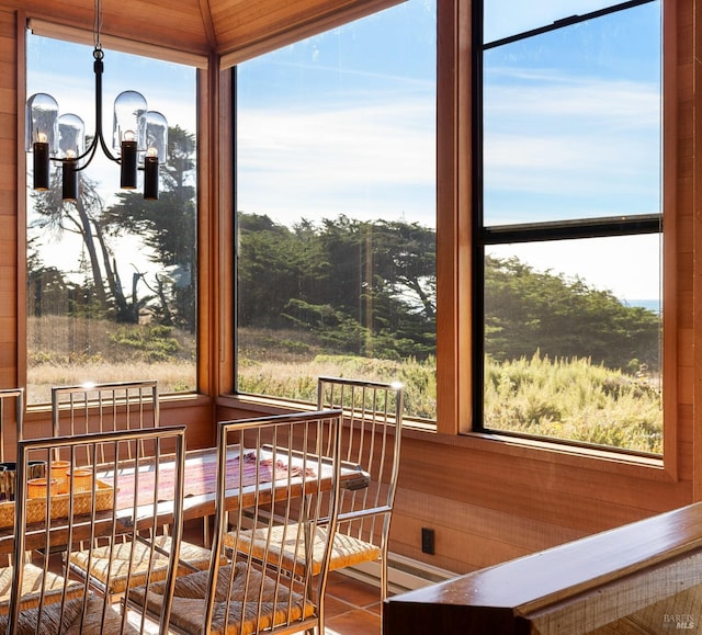 sunroom featuring plenty of natural light and a notable chandelier