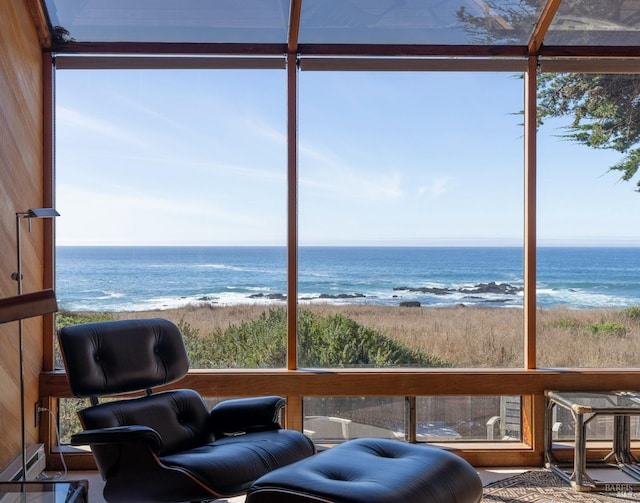 sunroom featuring a water view and a view of the beach