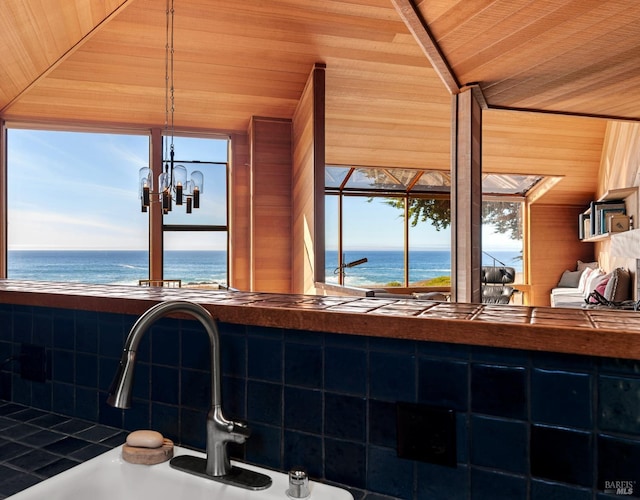 bathroom with a water view, a wealth of natural light, sink, and wooden ceiling