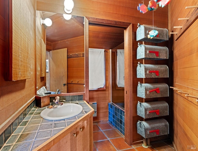 bathroom featuring tile patterned floors, vanity, and wooden walls