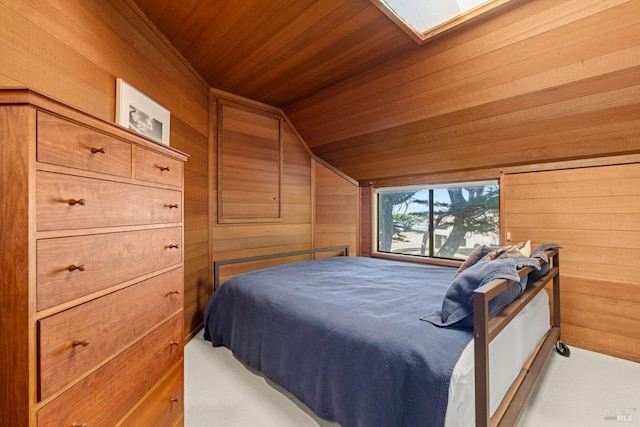 bedroom featuring wood ceiling, vaulted ceiling with skylight, and wood walls