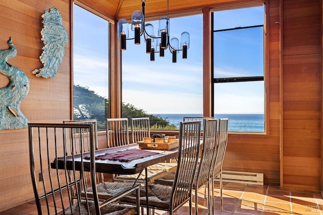 tiled dining space featuring a water view and a chandelier