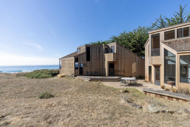 back of house with a patio area and a water view