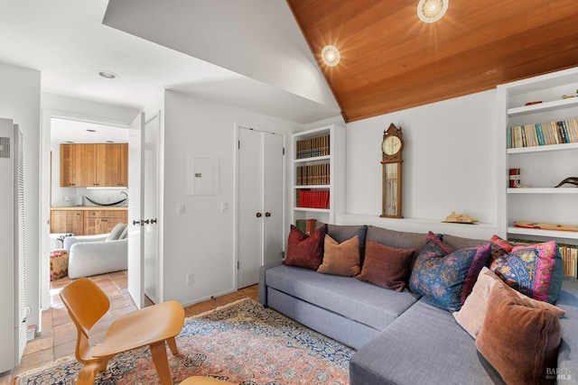 living room with vaulted ceiling, wood ceiling, and built in shelves