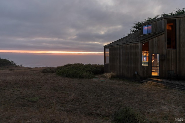 yard at dusk featuring a water view