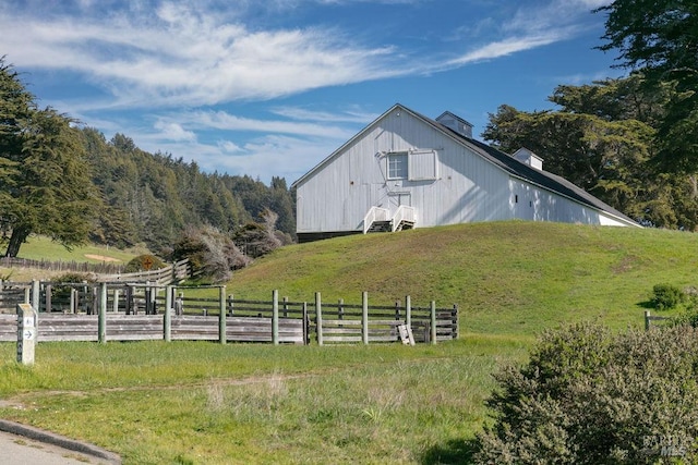 view of home's exterior featuring a rural view and a lawn