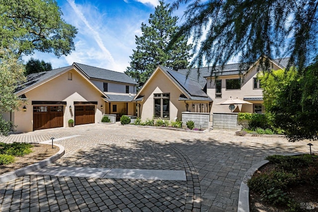 view of front of house with a garage and solar panels