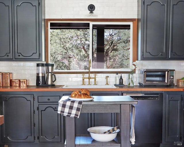 bar with decorative backsplash, plenty of natural light, dishwasher, and a sink