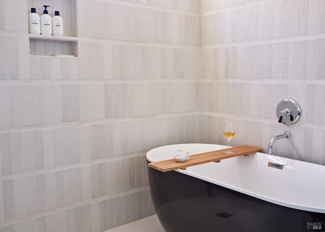 bathroom featuring a soaking tub and tile walls