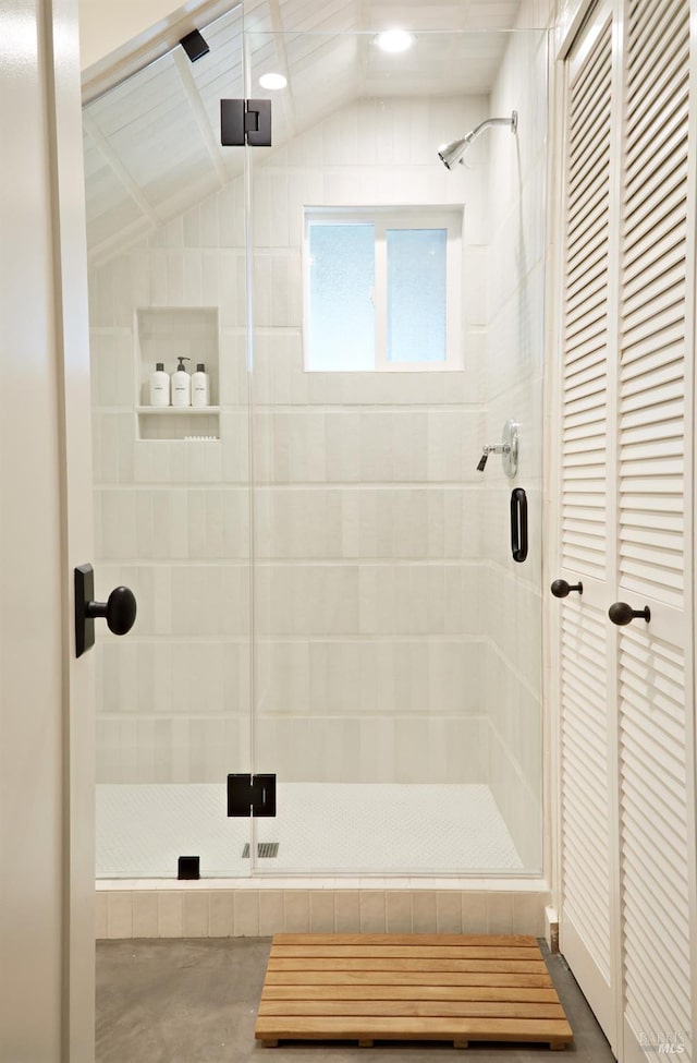 bathroom with a stall shower and vaulted ceiling