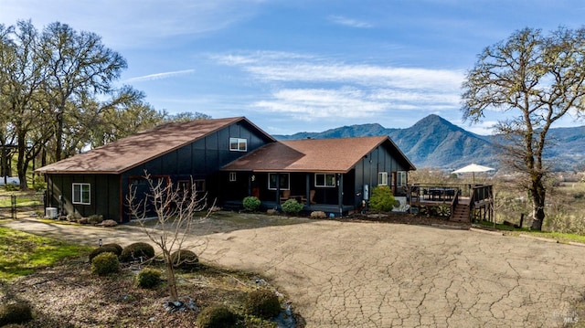 view of front of property with board and batten siding, a mountain view, and stairs