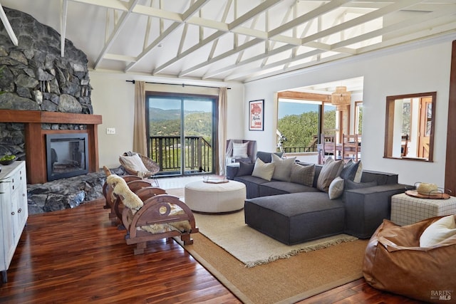 living area featuring dark wood-style floors, lofted ceiling with beams, and a fireplace