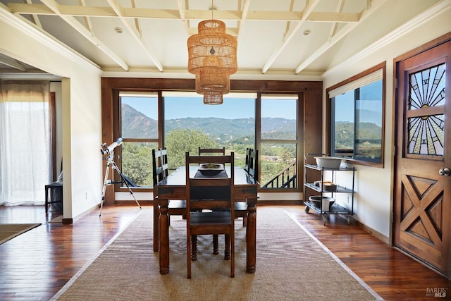 dining room featuring dark wood-style flooring, coffered ceiling, a mountain view, and baseboards