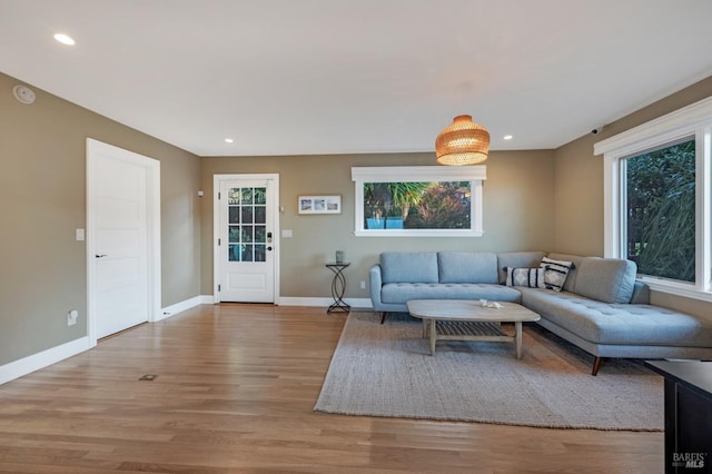 living area featuring light wood-type flooring, baseboards, and recessed lighting