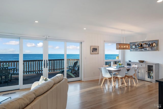 dining room with recessed lighting, a water view, visible vents, baseboards, and light wood-style floors