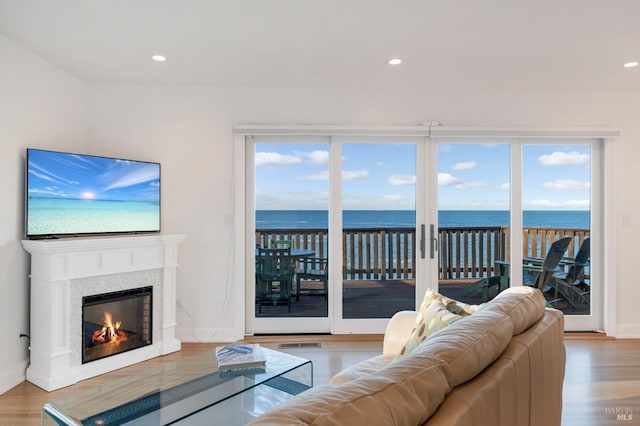 living room with light wood finished floors, a water view, and visible vents