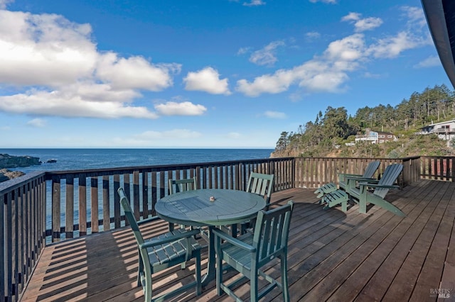 wooden terrace featuring a water view and outdoor dining area