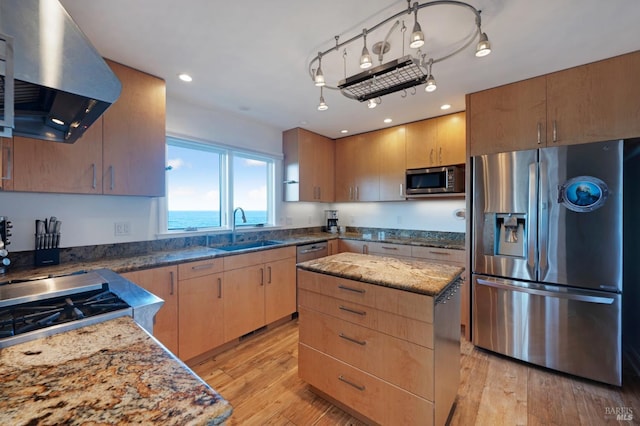 kitchen with island exhaust hood, stainless steel appliances, a water view, a sink, and a kitchen island