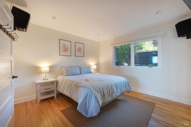 bedroom with light wood-type flooring and baseboards