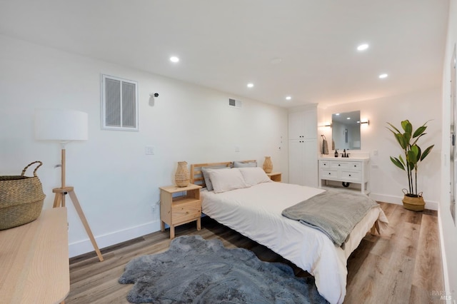 bedroom featuring light wood-style flooring, visible vents, and recessed lighting