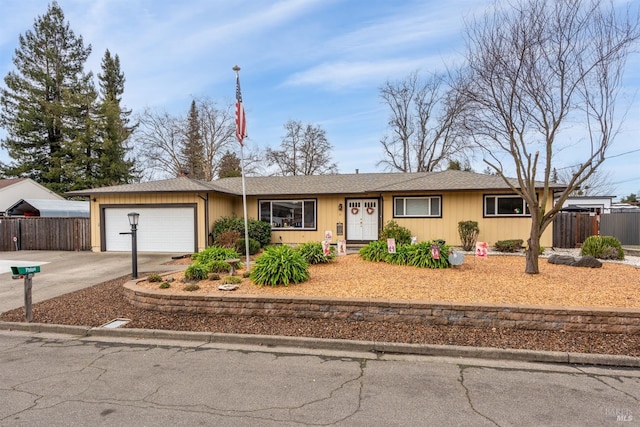 single story home with driveway, an attached garage, and fence